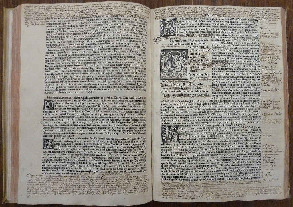 Due pagine di un libro stampato nel Quattrocento, con i margini fitti di note scritte a mano da un lettore.